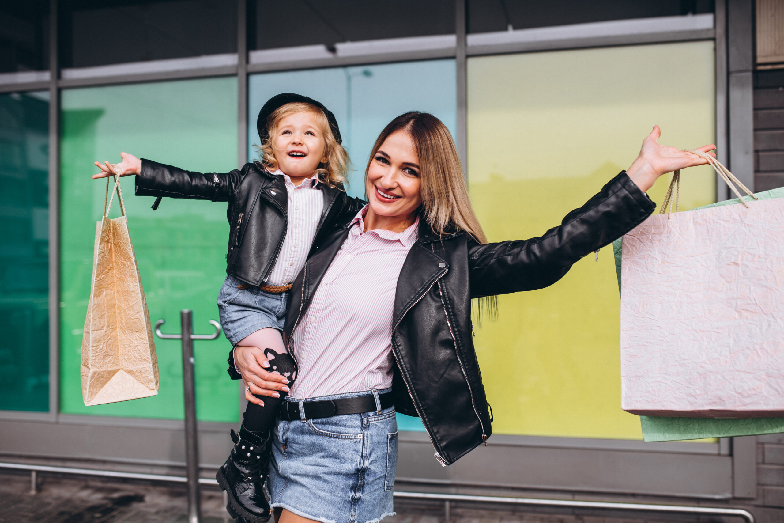 Mother with her little cute daughter with shopping bags